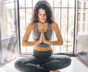 Junges Mädchen macht Yoga am Fenster - CAVF84824