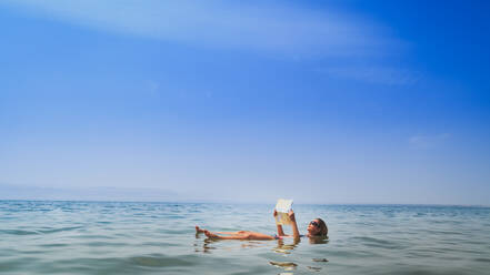 Scenic View Of Woman Floating In The Red Sea While Reading - EYF05098