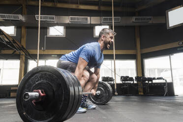 Mann hebt Gewichte im Fitnessstudio - EYF05132