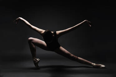 Balletttänzerin tanzt gegen grauen Hintergrund - EYF05208