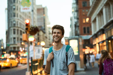 Fröhlicher junger Mann auf der Straße in der Stadt - EYF05234