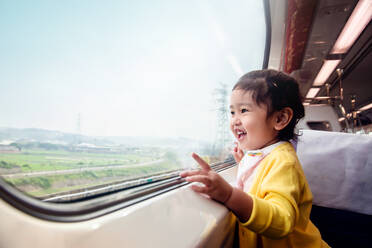 Seitenansicht des niedlichen Mädchens Blick durch das Fenster im Zug - EYF05272