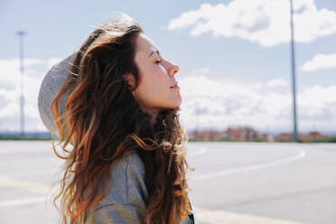 Side View Of Smiling Woman With Eyes Closed Day Dreaming On Street - EYF05274