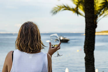 Frau mit Wein am Strand gegen den Himmel - EYF05280