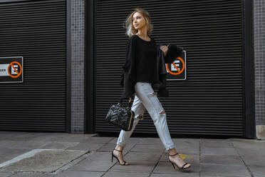 Full Length Of Fashionable Woman Walking On Footpath - EYF05311