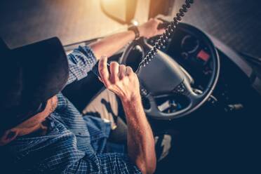 High Angle View Of Driver Holding Radio Walkie-Talkie In Truck - EYF05316