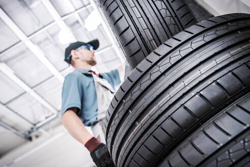 Low Angle View of Mechanic By Tires - EYF05337