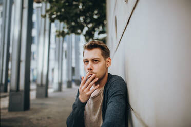 Young Man Smoking Cigarette Outdoors - EYF05401