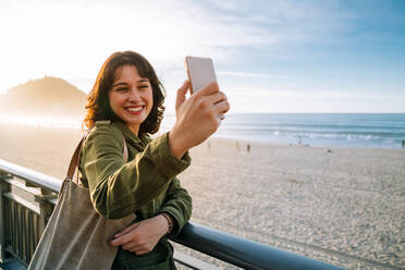 Junge Frau, die ein Selfie am Strand macht - EYF05418