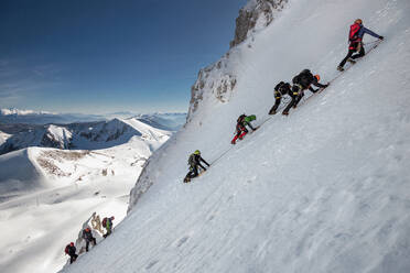 Menschen, die im Winter auf schneebedeckten Bergen klettern - EYF05421