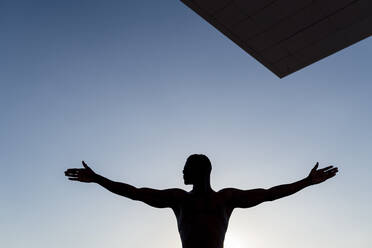 Worship. Silhouette of a man with arms stretched out to the sky