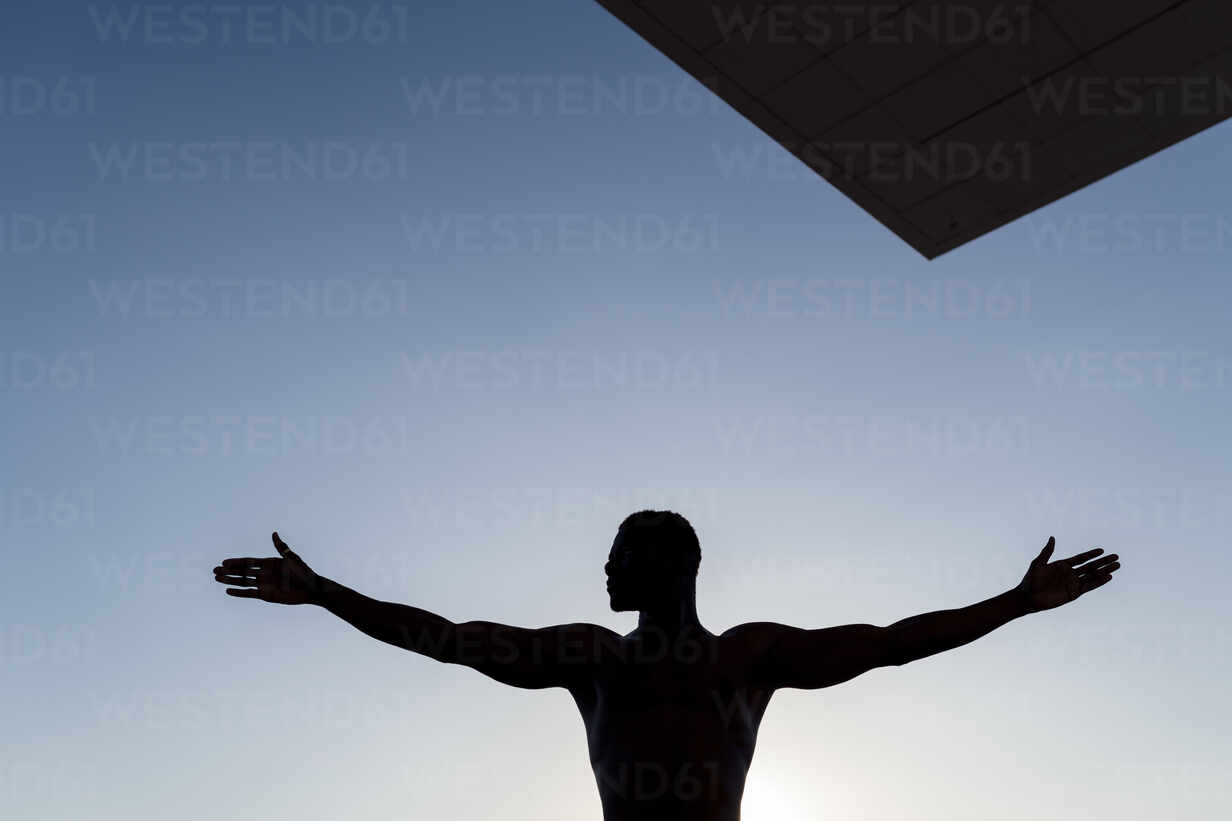 https://us.images.westend61.de/0001395027pw/silhouette-of-man-stretching-out-arms-against-clear-sky-EGAF00170.jpg