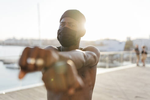 Black man with beanie and face mask, crossing fists - EGAF00172