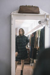 Junge Frau probiert ein Kleid an und schaut in den Spiegel im Designstudio - ALBF01289