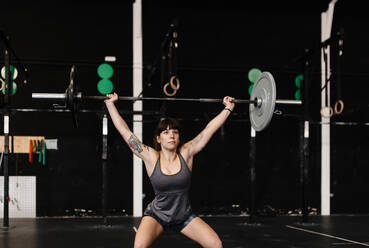 Weibliche Athletin beim Kreuzheben im Stehen im Fitnessstudio - MRRF00089
