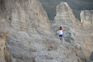 Ein Mann beim Trailrunning auf einem sandigen Gelände aus alten Bergbauabfällen - CAVF84917