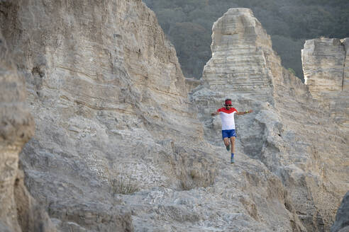 Ein Mann beim Trailrunning auf einem sandigen Gelände aus alten Bergbauabfällen - CAVF84917