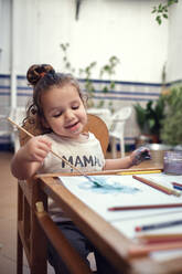Kinder spielen in einem Innenhof und malen mit Wasserfarben - CAVF84934