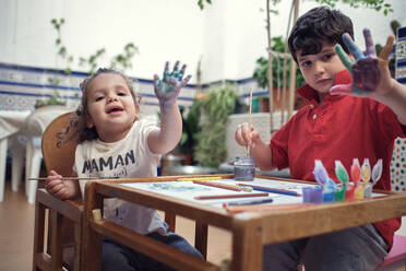 Children playing in an inner courtyard and painting with water paints - CAVF84935