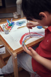 Kinder spielen in einem Innenhof und malen mit Wasserfarben - CAVF84938