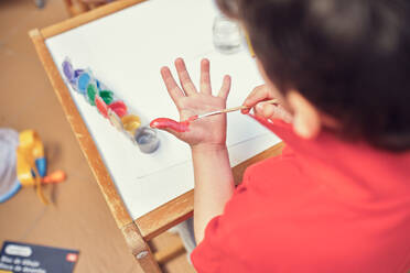Kinder spielen in einem Innenhof und malen mit Wasserfarben - CAVF84946