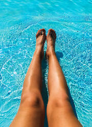 Female legs in the blue water of the pool - CAVF84968