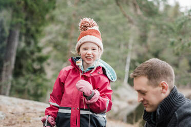Junges Mädchen lächelt beim Essen eines Marshmallows beim Camping in Schweden - CAVF84987