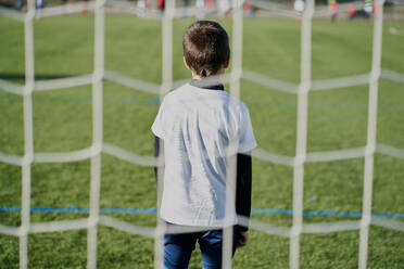 Rückansicht hinter dem Netz eines Kinderfußballtorwarts im Tor - CAVF85001