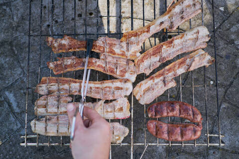 Preparation of barbecue on bacon and sausage grill stock photo