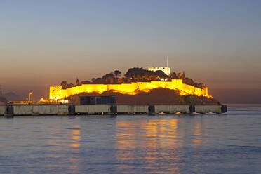 Die in der Abenddämmerung beleuchtete Festung aus der byzantinischen Zeit auf Guvercin Ada (Taubeninsel) an der Ägäisküste, in Kusadasi, Türkei, Kleinasien, Eurasien - RHPLF15174