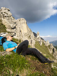 Älterer Mann auf dem Berg Grignetta liegend gegen den Himmel, Europäische Alpen, Lecco, Italien - MCVF00439