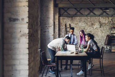 Kreativteam bei einer geschäftlichen Besprechung im Loft-Büro mit Laptop - MEUF00631