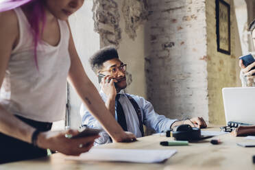 Creative team having business meeting in loft office using smartphones - MEUF00653