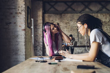 Zwei kreative Geschäftsfrauen machen eine Pause im Loft-Büro - MEUF00655