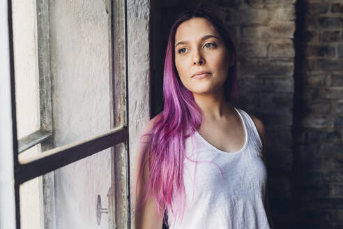 Portrait of a stylish young woman with pink hair in loft - MEUF00680