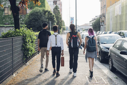 Gruppe von Freunden, die auf dem Bürgersteig in der Stadt spazieren gehen - MEUF00762
