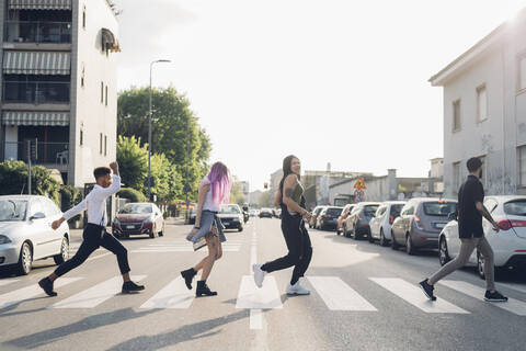 Gruppe von Freunden beim Überqueren einer Straße in der Stadt, lizenzfreies Stockfoto
