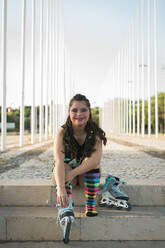 Teenager girl with down syndrome wearing 80s colorful make-up and roller skates - DCRF00282