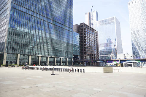 UK, England, London, Leerer Platz in den Londoner Docklands mit Wolkenkratzern im Hintergrund - PMF01088