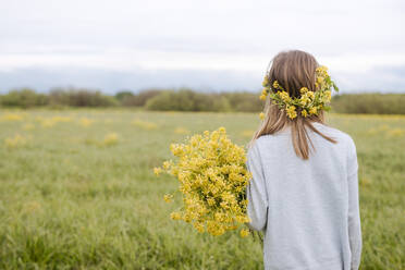 Rear view of girl with wreath and rape flowers - EYAF01139