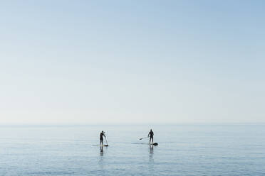 Reife Männer Paddleboarding auf dem Meer gegen den Himmel - DLTSF00760