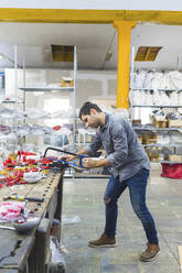 Man working with saw on fencing supplies on workbench - MEUF00878