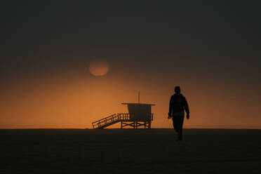 Skateboarder auf dem Weg zum stimmungsvollen Sonnenuntergang in Venice Beach, CA USA - CAVF85076