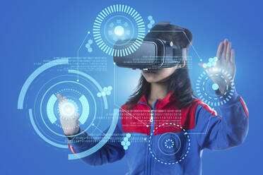 Digitales Kompositbild eines Mädchens, das einen Virtual-Reality-Simulator vor blauem Hintergrund benutzt - EYF05566