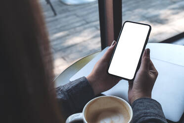 Cropped Image Of Woman Using Mobile Phone In Cafe - EYF05658