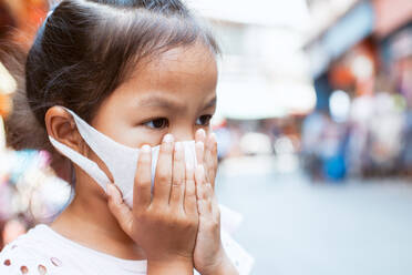 Close-Up Of Cute Girl Wearing Mask At Market - EYF05667