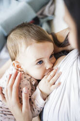 Close-Up High Angle View Of Mother Breastfeeding Daughter At Home - EYF05682