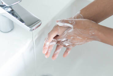 Frau wäscht Hände im Waschbecken - EYF05712