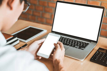 Rear View Of Businessman Using Phone At Desk In Office - EYF05719