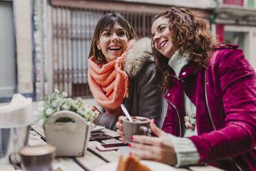 Friends Talking While Sitting At Sidewalk Cafe - EYF05725